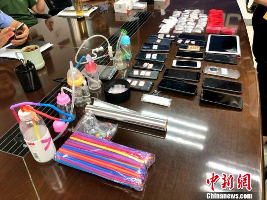 圖為警方繳獲的吸毒工具、作案手機(jī)及毒品等?！∠默?攝