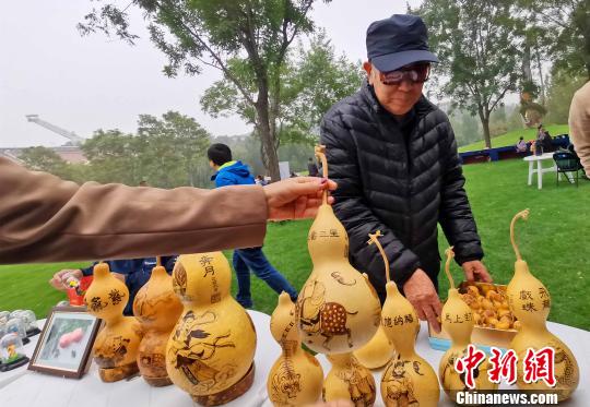 在10月19日開幕的“第二屆金海湖紅葉觀賞季”老北京市集上，有面塑、風(fēng)箏、烙畫葫蘆、瓦當(dāng)制作、拉洋片、刺繡、鏨刻、剪紙、毛猴、發(fā)繡等民俗技藝展示。　張一陽 攝