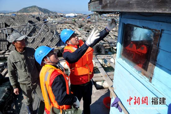 圖為1月8日，連江縣供電公司服務(wù)隊隊員在漁排上為漁民用電線路進行巡查，消除潛在的安全隱患，確保漁民們在春節(jié)期間生產(chǎn)和生活用電安全。